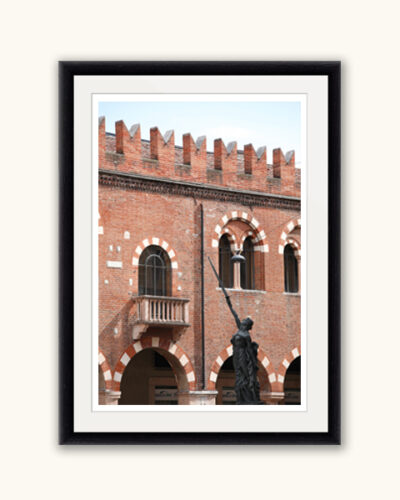 Framed print of a statue of a woman holding a sword in front of the walls of Palazzo della Ragione in Verona, Italy captured by Photographer Scott Allen Wilson
