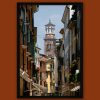 Colorful framed print of a narrow street in Verona, Italy guiding to the clocktower of Palazzo della Regione captured by Photographer Scott Allen Wilson.