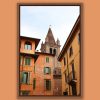 Artistic framed photo of Campanile of San Tommaso standing out between colorful buildings in Verona, Italy taken by Photographer Scott Allen Wilson