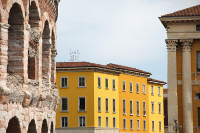 Colorful photo of the Amphitheater of Verona, Italy next to a bright yellow building taken by Photographer Scott Allen Wilson.