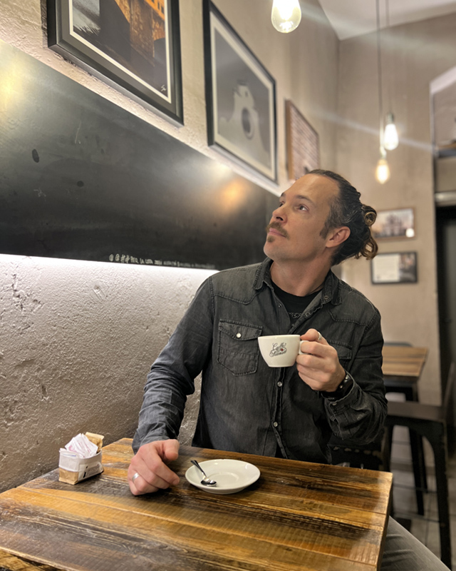 Photo of Photographer Scott Allen Wilson at his exhibition located at Caffetteria Piansa on Via Gioberti in Florence, Italy