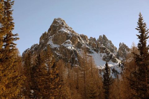 Beautiful mountain peaks of the Dolomites, Italy surrounded by reddish trees, taken by Photographer Scott Allen Wilson