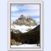 Beautiful white framed landscape photography of the tall Dolomites mountain range in Italy with a forest and houses below, taken by Photographer Scott Allen Wilson.