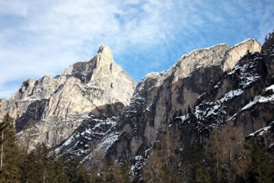 Close shot of the rocky mountain peaks in the Dolomites, Italy with pine trees at the bottom taken by Photographer Scott Allen Wilson.
