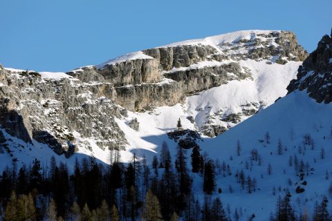 A jagged mountain of the Dolomites, Italy covered in snow and with a light blue sky in the background taken by Photographer Scott Allen Wilson.