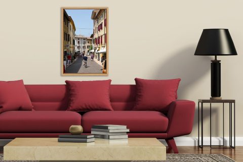 Modern living room decoration with a red sofa and a framed print of Lazise, Italy taken by Photographer Scott Allen Wilson.