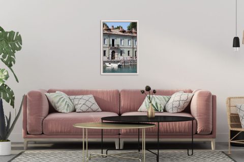 Pink living room decoration with a framed print of a traditional building at the edge of the water taken in Peschiera del Garda, Italy by Photographer Scott Allen Wilson.