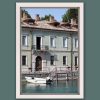 White framed print of a traditional building at the edge of the water taken in Peschiera del Garda, Italy by Photographer Scott Allen Wilson.