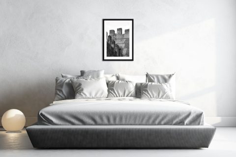 Minimalist gray bedroom decoration with a black and white framed print showing the different angles and geometric shapes of Castello Scagliero di Lazise in Italy taken by Photographer Scott Allen Wilson.