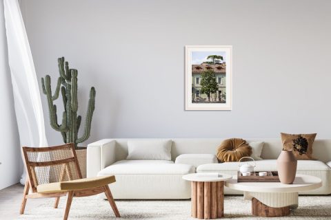 Minimalist wooden living room decoration with a print on a white frame of a green building with a beautiful tree in front taken in Peschiera del Garda, Italy by Photographer Scott Allen Wilson.
