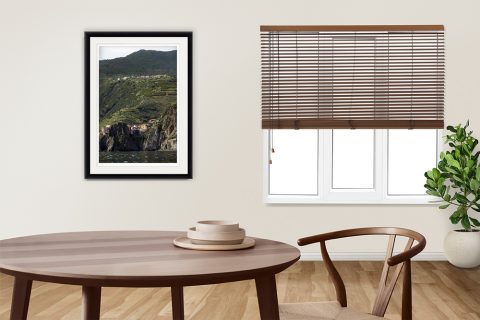 Wooden flooring and dark wood decor are elevated by the print of Cinque Terre, Italy by Photographer Scott Allen Wilson.