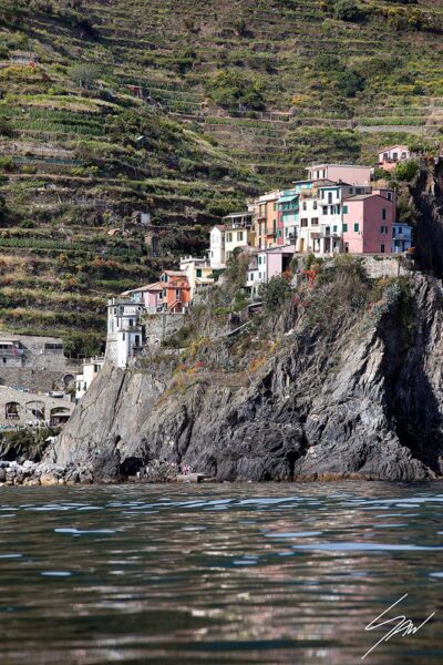 A view of Manarola in Cinque Terre, Italy, mounted up a peak over the sea. Captured by Photographer Scott Allen Wilson.
