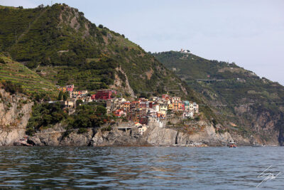 View of Manarola in Cinque Terre, Italy. Colorful houses dot the hills overlooking the sea. By Photographer Scott Allen Wilson.