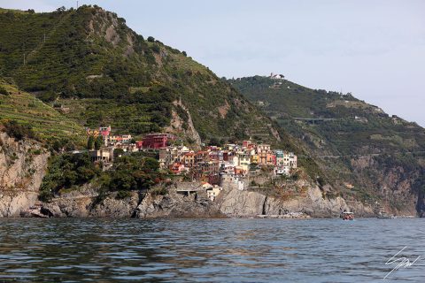 View of Manarola in Cinque Terre, Italy. Colorful houses dot the hills overlooking the sea. By Photographer Scott Allen Wilson.