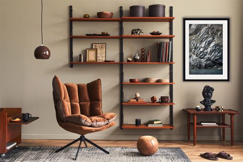 A modern living room with leather and wooden accents is elevated by a print of Monterosso al Mare, Italy. By Photographer Scott Allen Wilson.