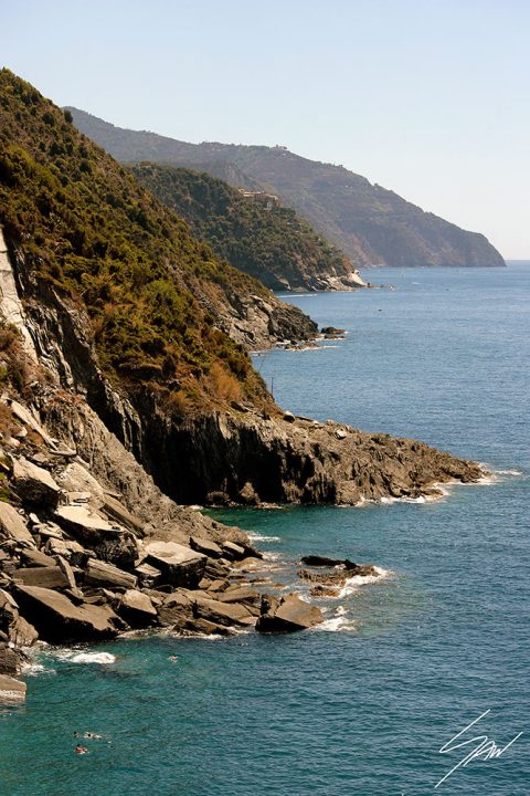 A shot of Vernazza, Italy, showing the rocky coastline slowly blending into the crystal-clear waters of Liguria. By Photographer Scott Allen Wilson.