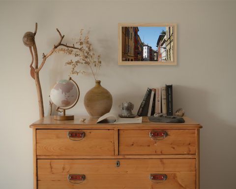 A print of the streets of Parma hung in a beige room with wooden minimal decor. By Photographer Scott Allen Wilson.