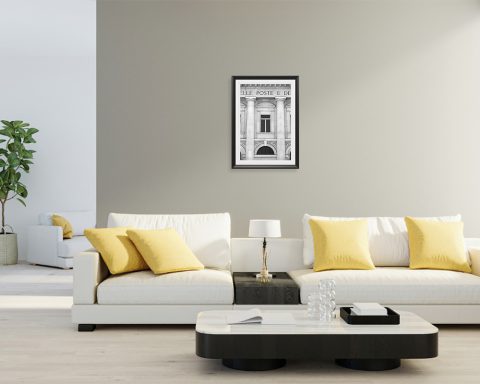 A black framed print of the post office in Pescara, Italy, hanging in a room with neutral modern decor. By Photographer Scott Allen Wilson.