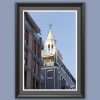 A black framed print of a clock tower in Pescara, Italy, standing out behind modern buildings. By Photographer Scott Allen Wilson.