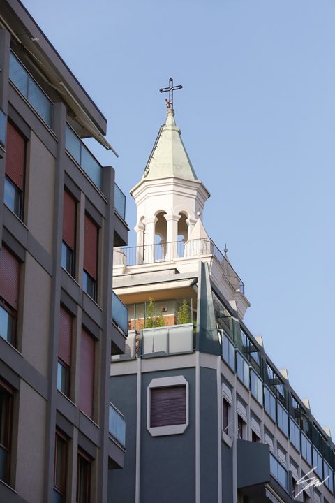 A print of a clock tower in Pescara, Italy, standing out behind modern buildings. By Photographer Scott Allen Wilson.