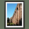 A black framed print of the red brick columns and archs leading to a church in the city of Lucca, Italy. By Photographer Scott Allen Wilson.