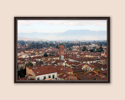 A dark brown framed print of a view of the city of Lucca, Italy. By Photographer Scott Allen Wilson.