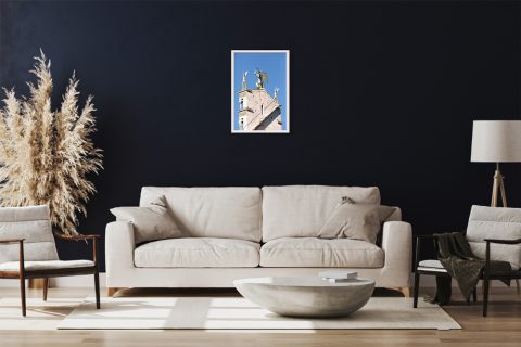 A white framed print of the Church of San Michele in Foro in Lucca, Italy, hanging in a modern living room. By Photographer Scott Allen Wilson.