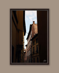 A dark brown framed print of rooftops in Lucca, Italy. By Photographer Scott Allen Wilson.