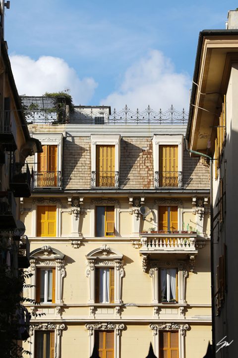 A cream colored residential house, brightly lit and richly decorated, stands proud between two more structures. Photo captured by Travel Photographer Scott Allen Wilson.