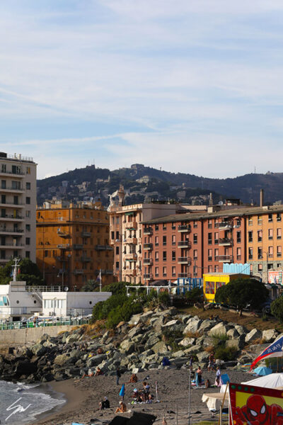Vibrant buildings at the seaside coast a rocky beach in Genova, Italy. Photo captured by Travel Photographer Scott Allen Wilson.