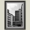 Wooden framed piece of art by Travel Photographer Scott Allen Wilson, featuring a black and white cityscape with tall blocks and linear windows.