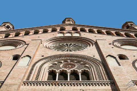 Fine art travel print of an upward view of an ornate historic brick facade featuring rose windows and intricate stone detailing, Looking to the East by Scott Allen Wilson, available in 8x12 and 16x24.