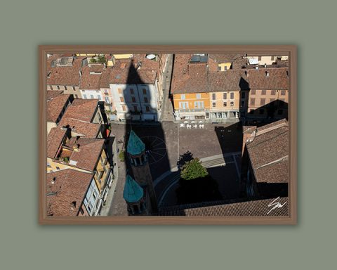 Fine art framed print of a sweeping aerial view of a historic Italian piazza with terracotta rooftops, a copper domed structure and a dramatic architectural shadow, The Source by Scott Allen Wilson, available in 8x12 and 16x24.