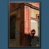 Fine art framed print of a sunlit Italian street corner with weathered terracotta walls and vintage street signs, Realdo Colombo by Scott Allen Wilson, available in 8x12 and 16x24.