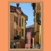 Fine art framed print of a vibrant Italian street with colorful pastel facades, shuttered windows and ornate ironwork balconies against a blue sky, Sicardo Vescovo by Scott Allen Wilson, available in 8x12 and 16x24.