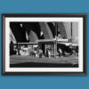 Black and white fine art photograph of an urban street scene in Recco displayed in a black frame with a white mat on a blue background.