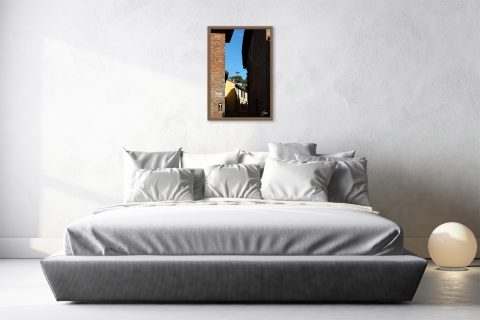 Fine art travel photograph of light and shadow between historic buildings in Pavia.