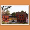 Travel framed print of colorful Italian buildings displayed in a modern living room interior.