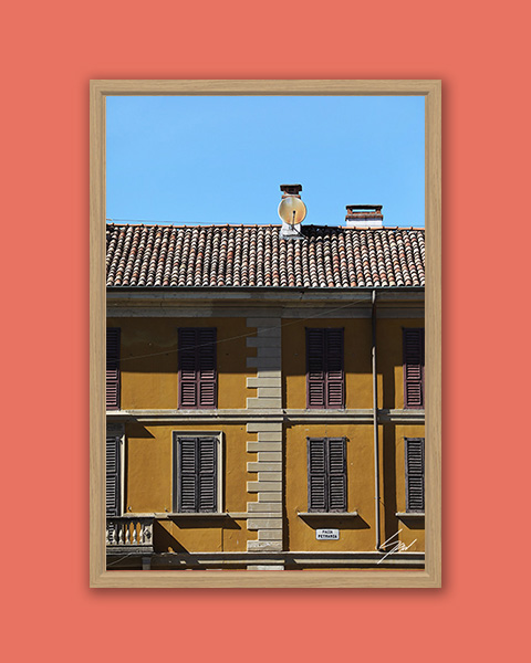 Framed travel art print of a mustard-colored facade in historic Pavia, Italy.