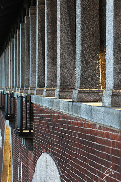 Fine art travel photograph capturing symmetry, depth, and texture along a covered walkway in Pavia.