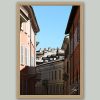 Framed travel art print of layered rooftops and pastel streets in historic Pavia, Italy.