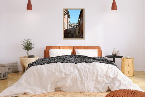Framed travel art print of layered rooftops and pastel streets in historic Pavia, Italy.