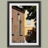 Framed travel art print of historic brick and faded facades in Pavia, Italy.