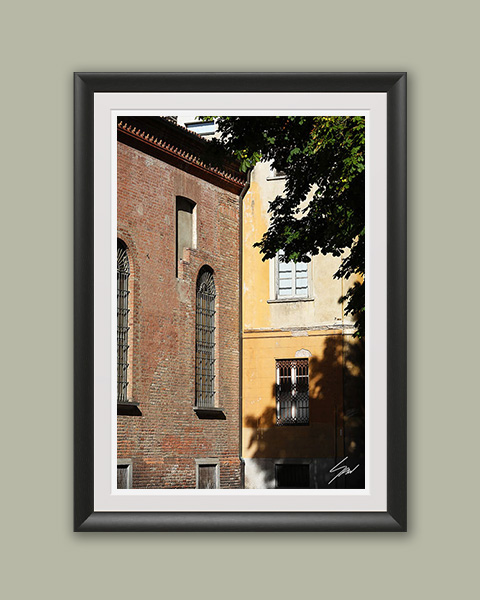 Framed travel art print of historic brick and faded facades in Pavia, Italy.