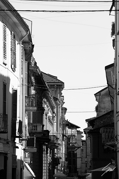 Framed B&W travel print featuring balconies, shadows, and urban textures in historic Italy.