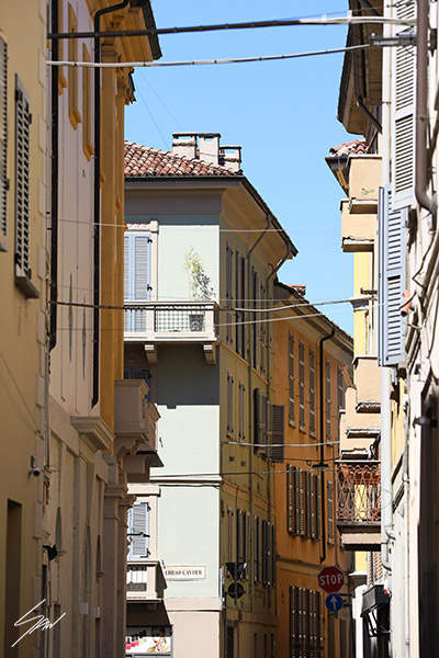 Fine art travel photograph capturing layered architecture, balconies, and overhead power lines in Pavia.