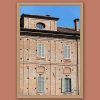 Framed travel art print of historic brick architecture and shuttered windows in Pavia, Italy.
