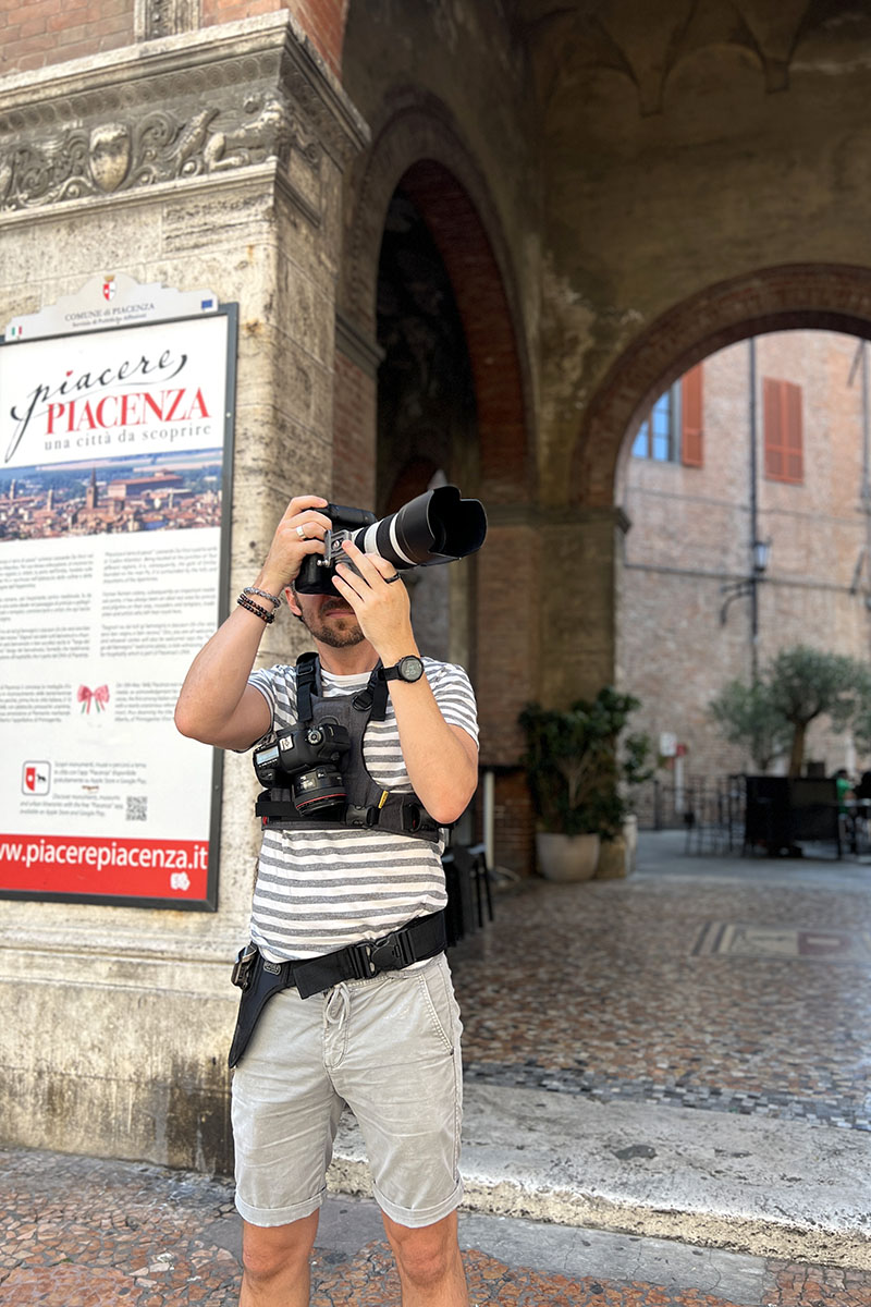 Travel photographer Scott Allen Wilson photographing architectural details beneath the arches of Palazzo Gotico in Piacenza.