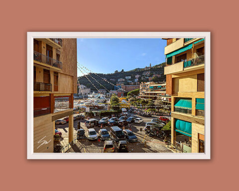 Fine art photograph looking toward the heart of Recco, where everyday life unfolds beneath colorful buildings and hillside homes.