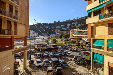 Fine art photograph looking toward the heart of Recco, where everyday life unfolds beneath colorful buildings and hillside homes.